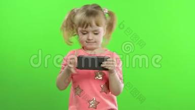 小女孩用智能手机。 有智能手机发短信、玩游戏的儿童肖像